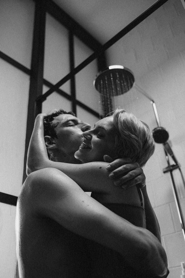 Grayscale Photo Of A Romantic Couple In The Bathroom