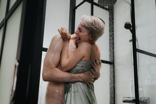 A couple shares a playful and intimate moment in the shower, evoking feelings of joy and connection.