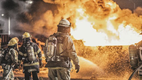 Firefighters Standing in Front of Flame