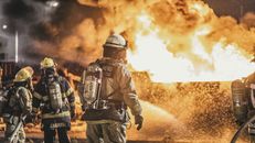Firefighters Standing in Front of Flame