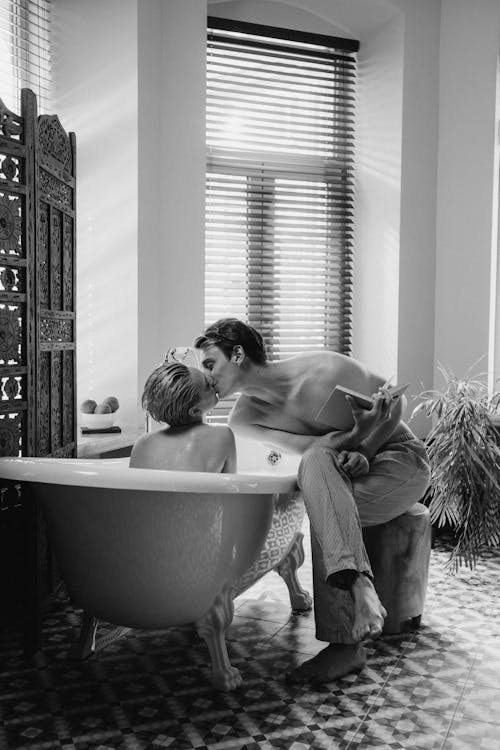 Free Grayscale Photo of Man and Woman Kissing on Bathtub Stock Photo