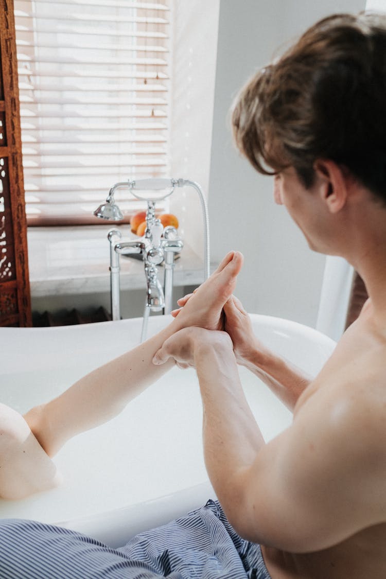 A Man Washing The Feet Of His Partner