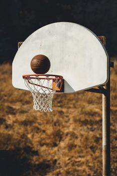 A basketball in motion nearing a hoop on an outdoor court in San Francisco.