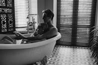 Grayscale Photo of Woman in Bathtub