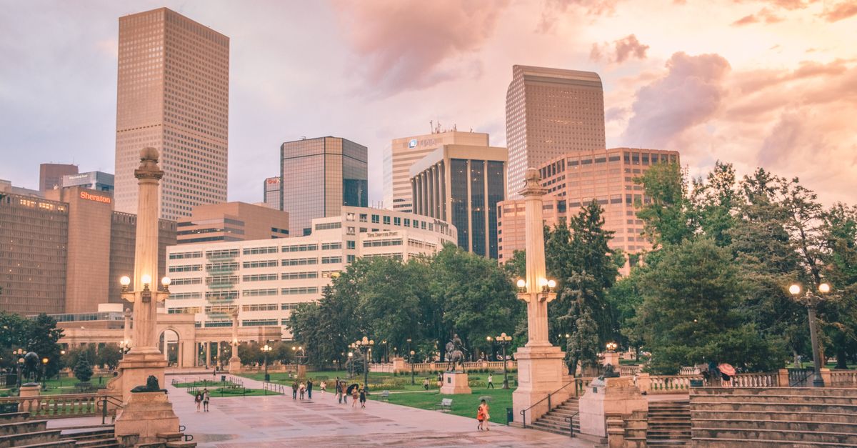 Stunning view of Denver's skyline with city park and people at sunset.