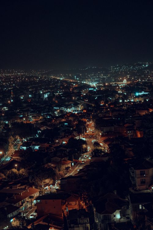 Free A mesmerizing aerial view of a vibrant cityscape illuminated at night with bright lights. Stock Photo