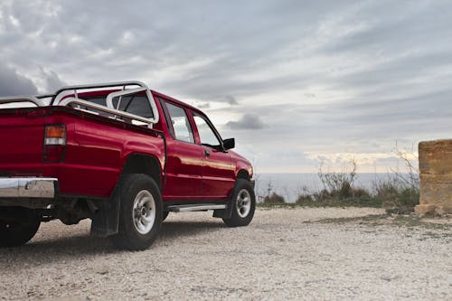 Free Red Pickup Truck Parked Near Wall Stock Photo