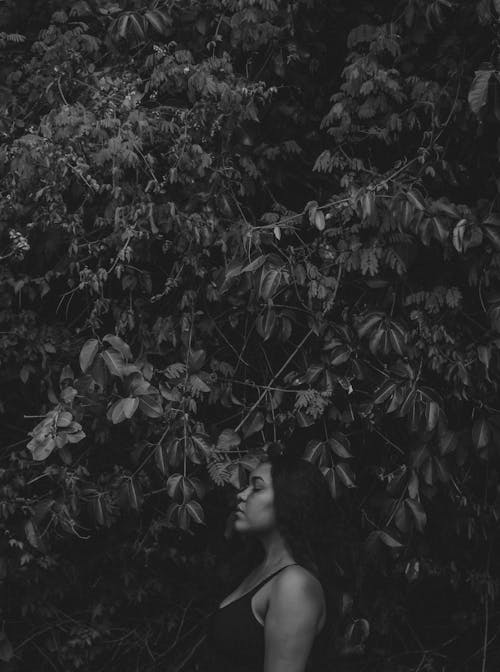 Grayscale Photo of Woman Surrounded by Plants