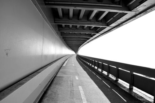 Free Black and white image of a curving highway tunnel with minimalist perspective. Stock Photo