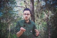 Man Wearing Green Dress Shirt and Surrounded by Trees