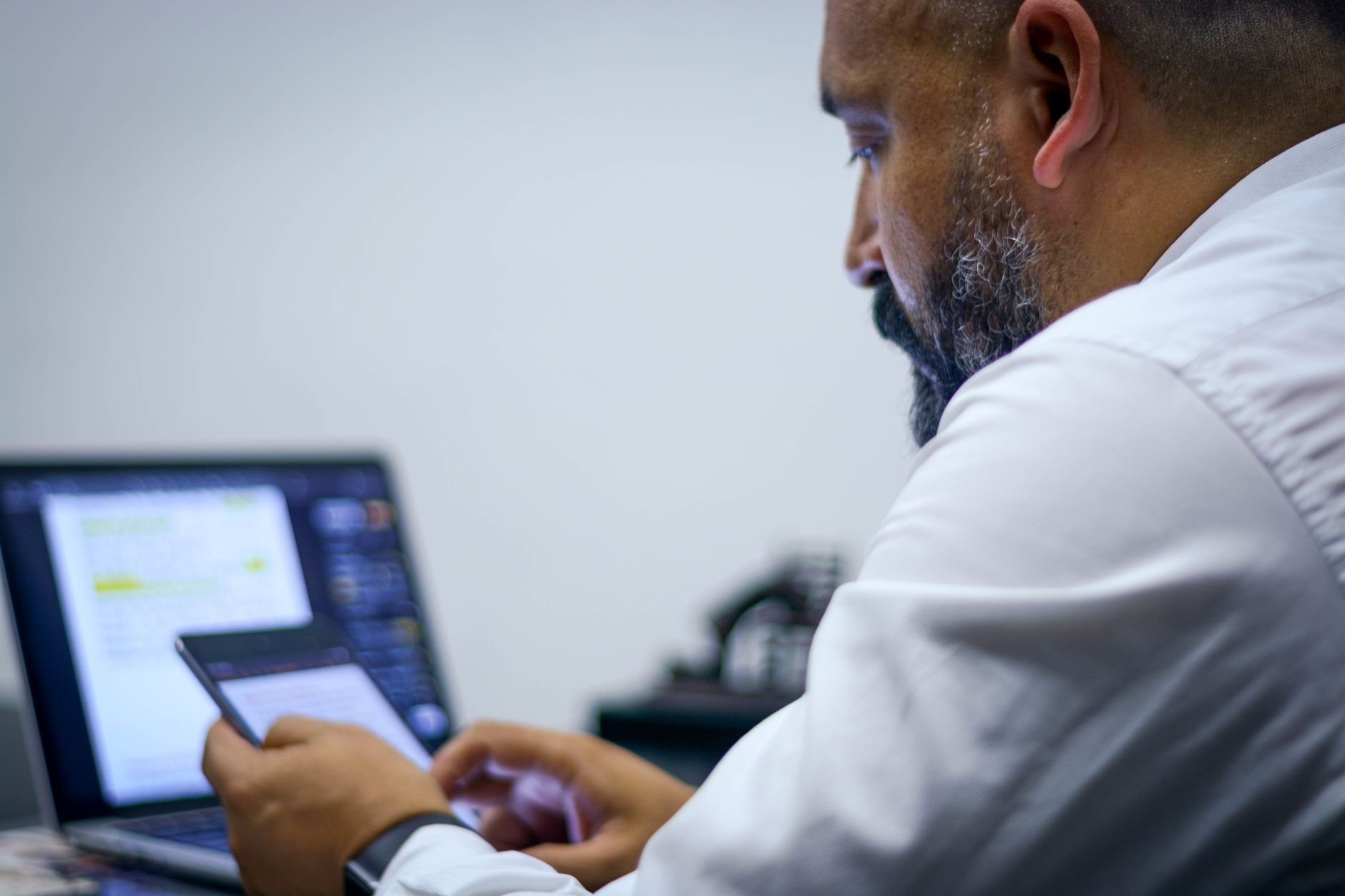 A coach reviewing a draft announcement email on screen in a professional workspace