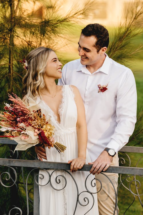 Man in White Dress Shirt Holding Bouquet of Flowers