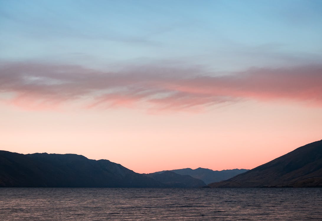 Body of Water With Mountains on Side