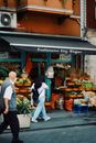 Woman in White Shirt and Blue Denim Jeans Standing in Front of Fruit Stand