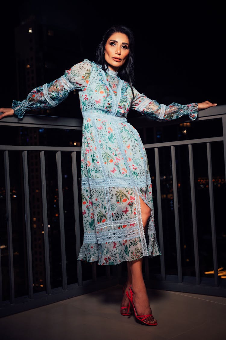 Woman In Dress Posing On Balcony At Night