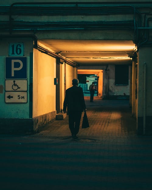 A Man Walking in a Hallway