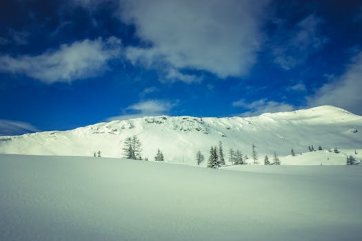 Breathtaking winter mountain scene with snow-covered peaks and a clear blue sky.