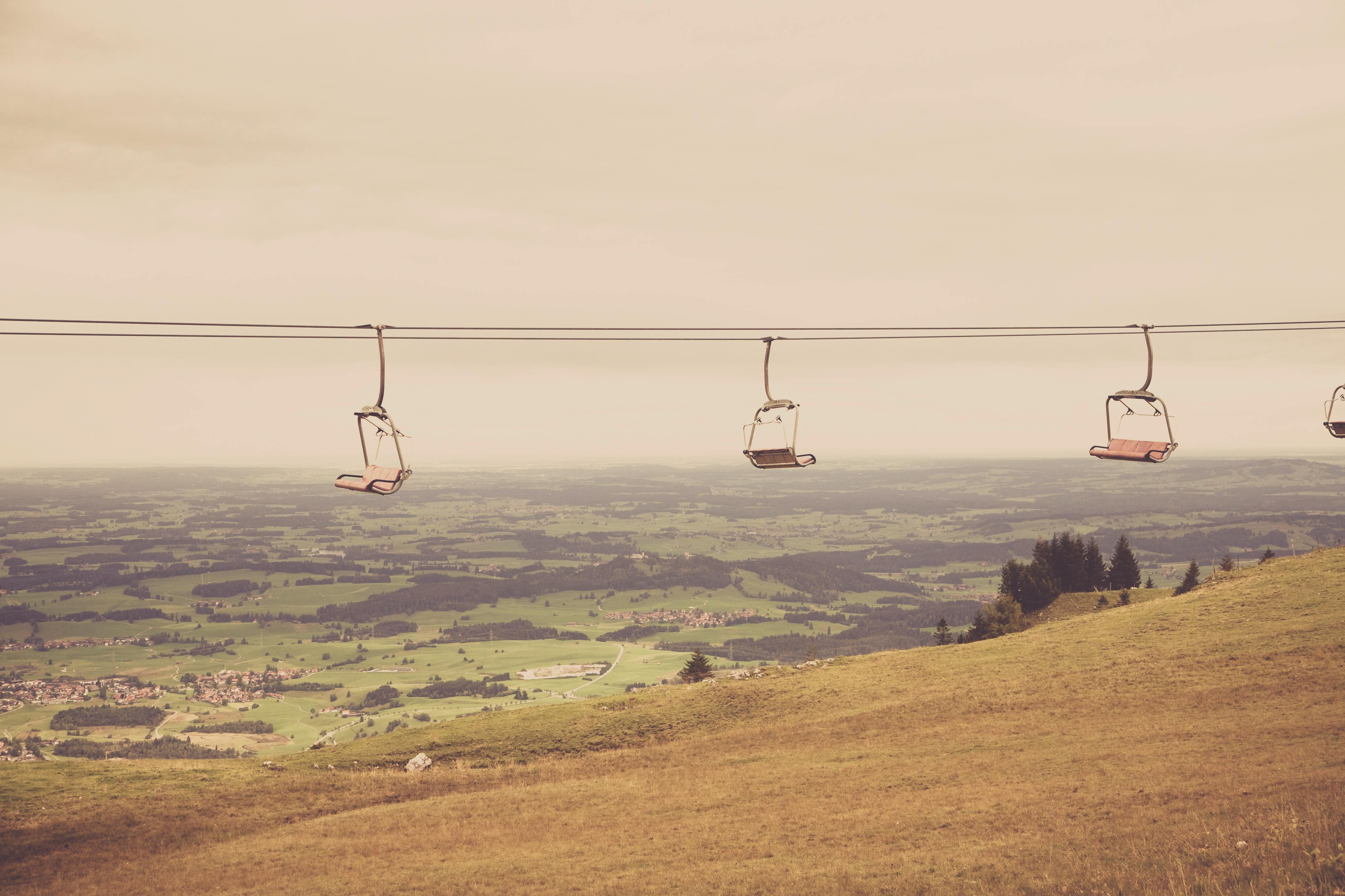 A serene chairlift over an expansive pastoral landscape, capturing a tranquil rural scene.