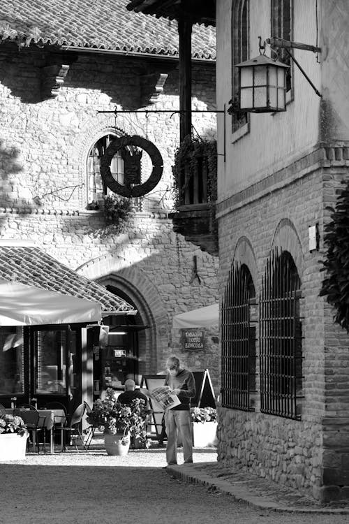 Free Man Reading a Newspaper Beside Old Brick Building Stock Photo