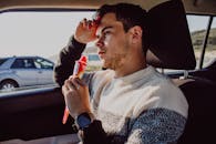 Man in White Sweater Holding Bottle