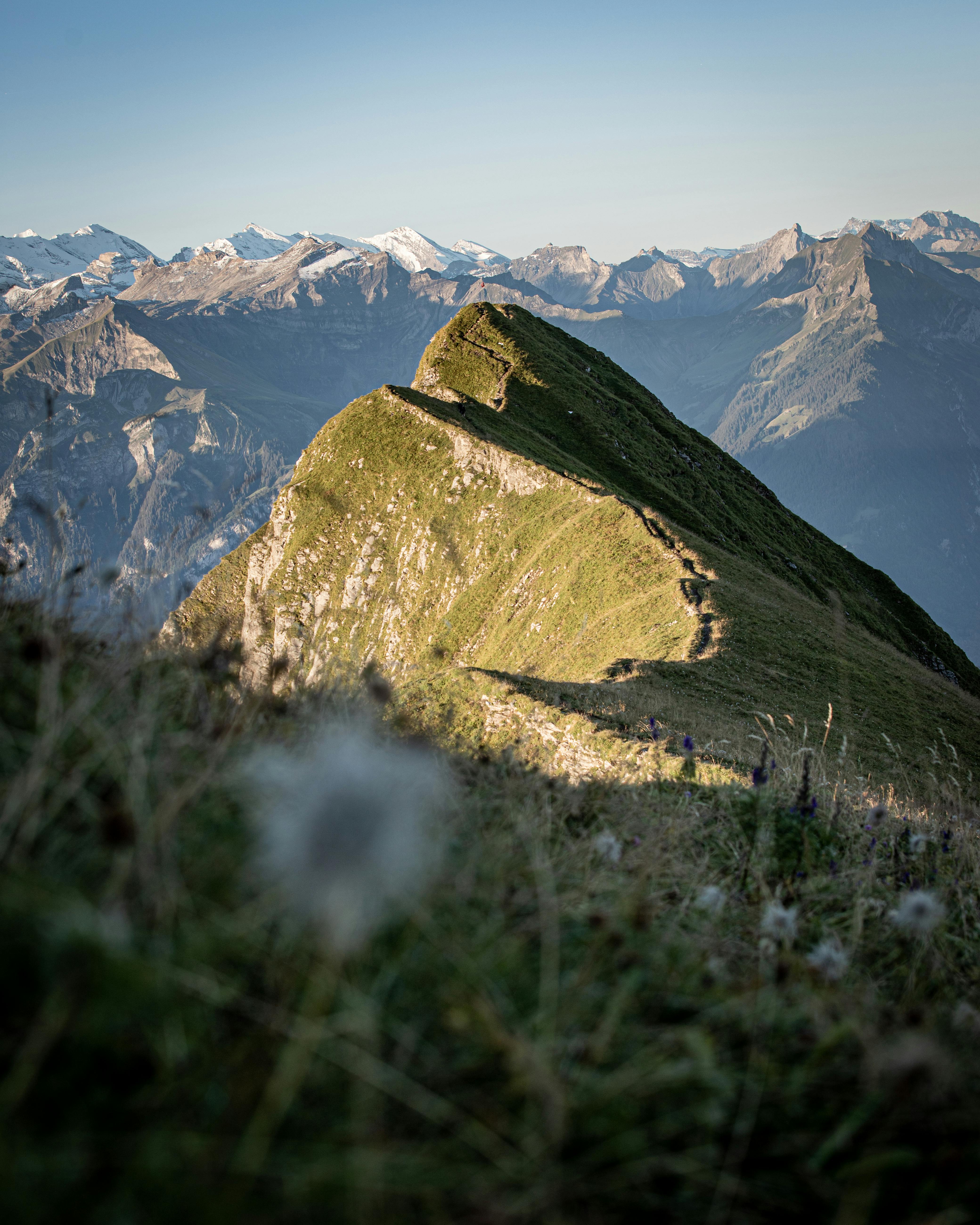 Breathtaking view of the Swiss Alps in Habkern with a green peak and distant snow-capped mountains.