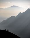 Silhouette of 2 People Standing on Rock Formation