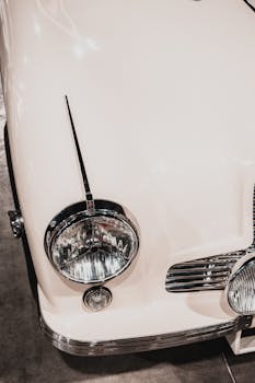 Close-up of a classic vintage car's chrome headlight showcasing intricate design.