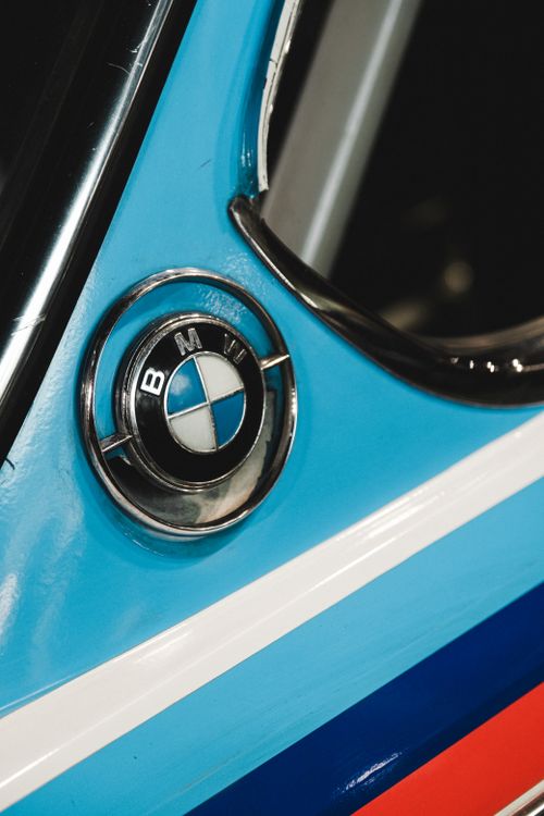 Free Detailed close-up shot of a BMW emblem on a blue vintage car with chrome details. Stock Photo