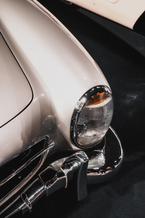 Free Detailed view of a classic car's chrome bumper and headlight, showcasing vintage design. Stock Photo