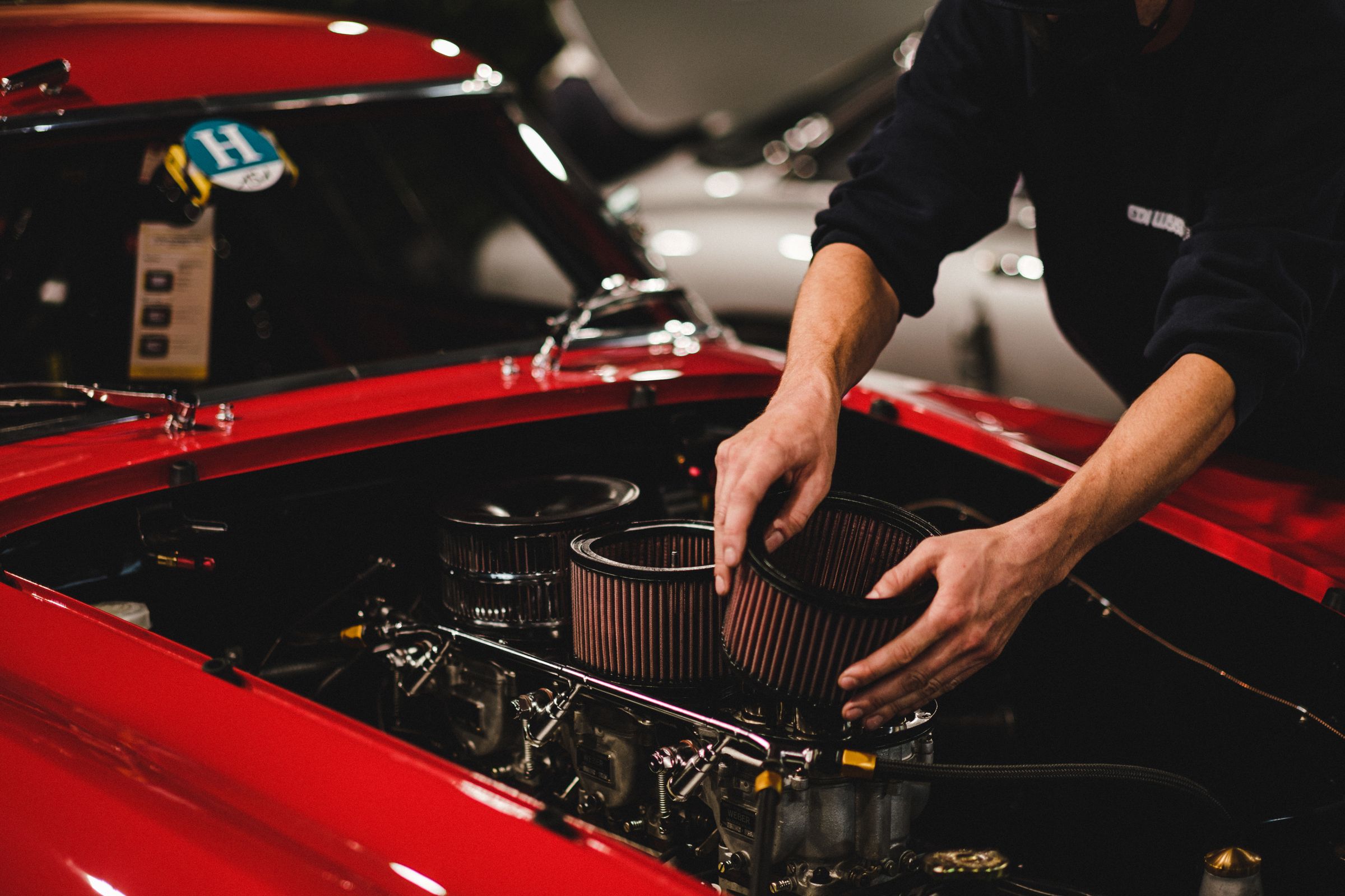 Mechanic removing a car engine air filter, a common auto shop upsell target