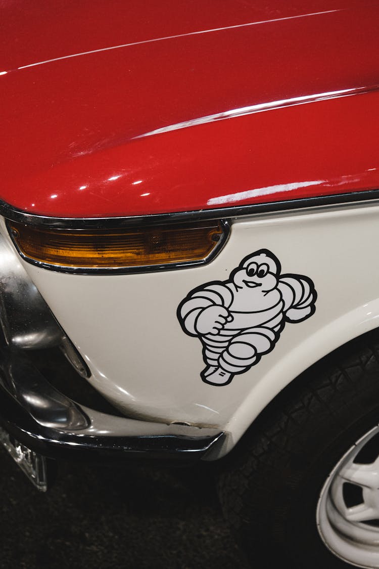 Red And White Car With Michelin Man Sticker On Bumper