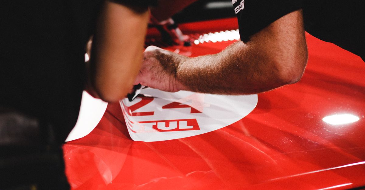 Men Putting Stickers on a Car · Free Stock Photo
