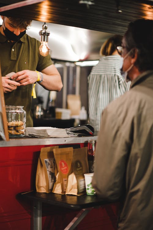 Man Buying Coffee near Counter