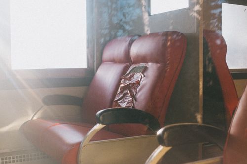 Free Close-up of vintage red leather seats with sunlight highlighting wear and tear. Stock Photo
