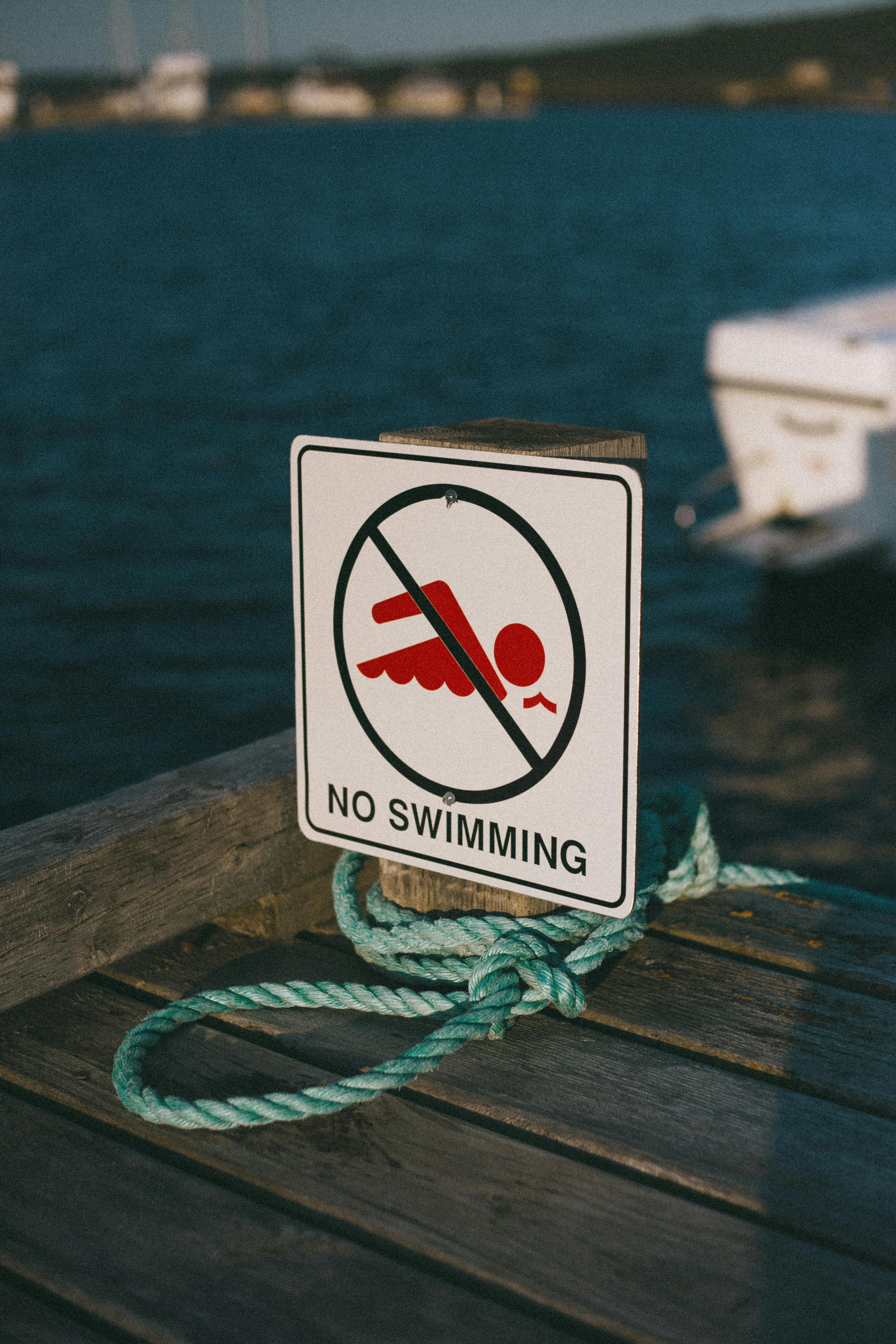 no swimming sign and a rope on the bridge