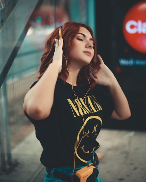 Woman in Black Shirt Listening to Music