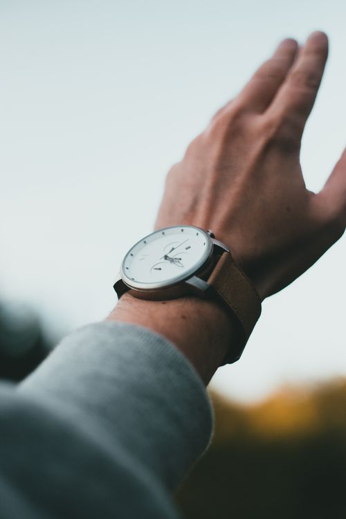 Free A stylish wristwatch on a person's raised hand, captured in a minimalist, artistic shot. Stock Photo