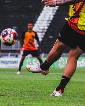 Focused action shot of football players practicing on a grassy field during a match.