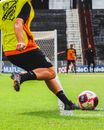 Woman in Orange and Black Jersey Shirt Playing Soccer