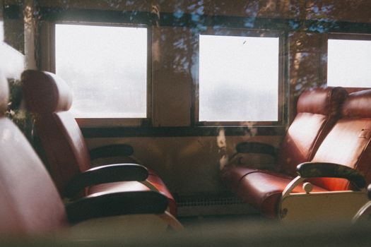Warm and inviting view of train interior showcasing leather seats and large windows.