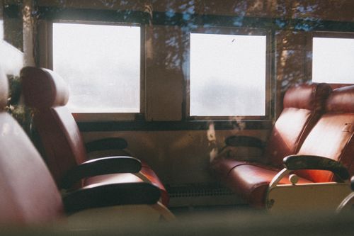 Free Warm and inviting view of train interior showcasing leather seats and large windows. Stock Photo
