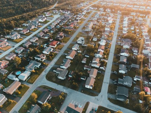Free A stunning aerial view of a peaceful suburban neighborhood at sunset with lined houses and streets. Stock Photo