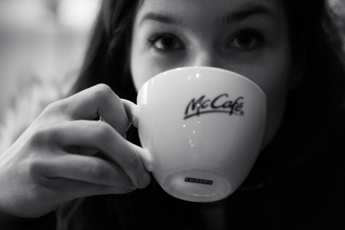 Grayscale Photography of Woman Drinking Coffee