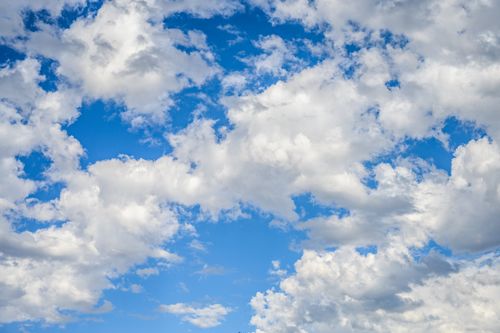 Free A vibrant blue sky filled with fluffy white clouds on a bright summer day. Stock Photo