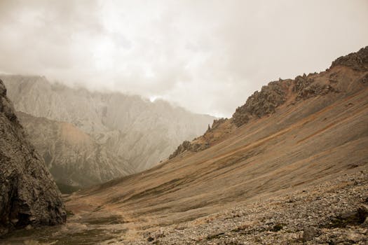 A stunning view of a rocky mountain landscape shrouded in clouds, creating a moody atmosphere.