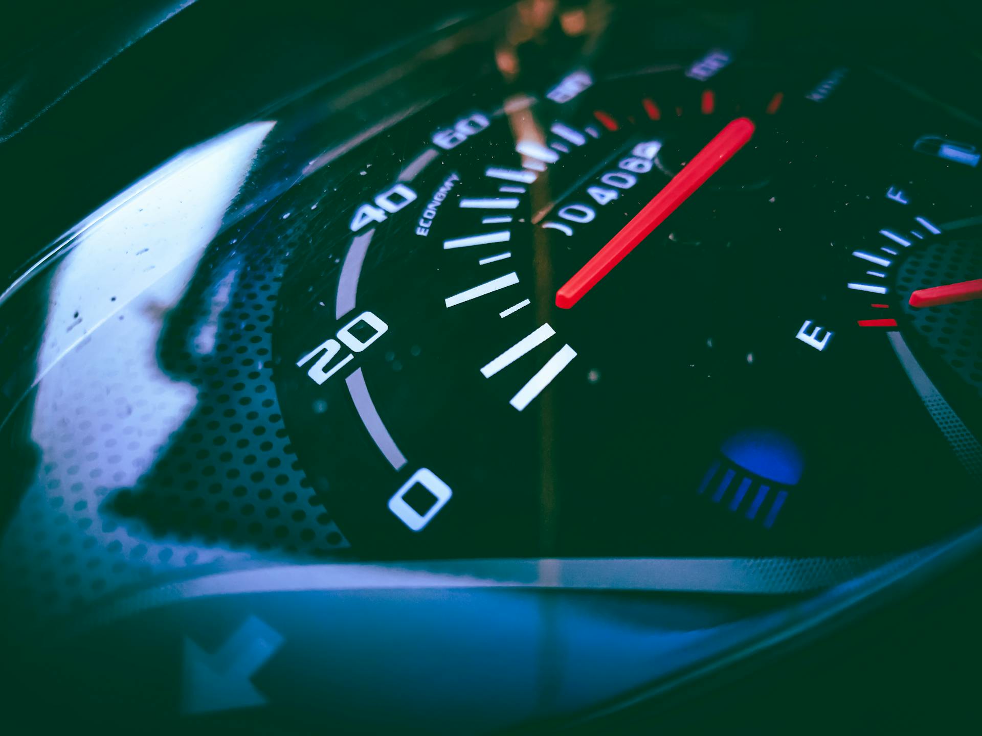 Detailed view of a speedometer and fuel gauge indicating measurement and fuel level.