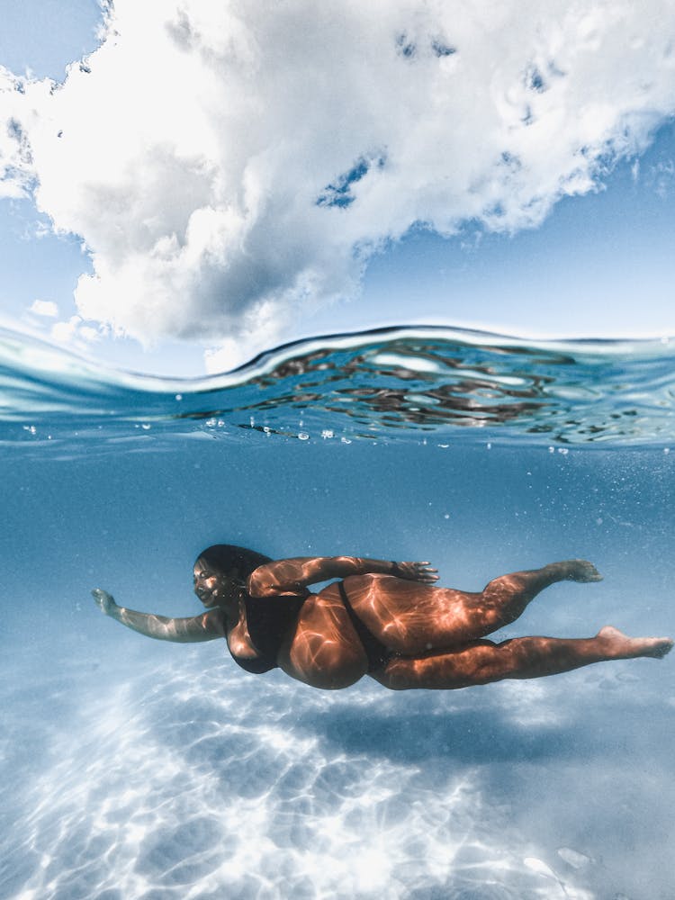 Woman In Black Bikini Swimming In Water