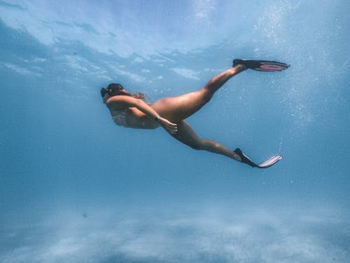 Woman in Black Bikini Swimming in Water