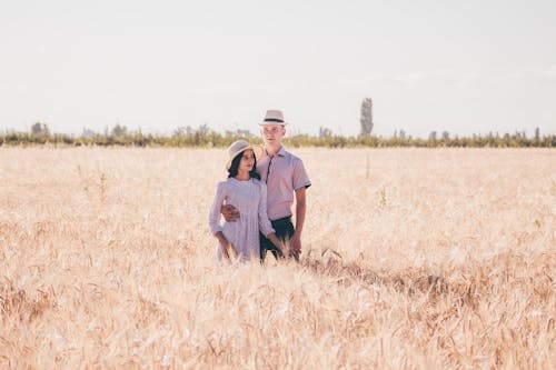 Couple Standing on Brown Grass Field