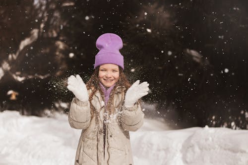 Young Girl Wearing Jacket and Purple Beanie Standing on Snow 